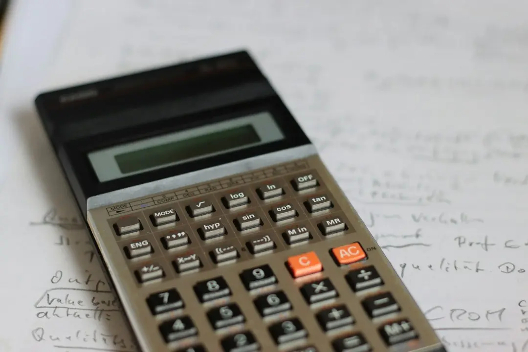 Una calculadora sobre unas notas manuscritas para comparar precios